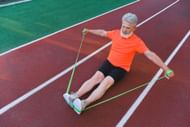 Seated knee extension can be done using a resistance band. (Photo via Pexels/Anna Shvets)